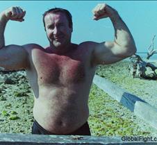 old man flexing beach