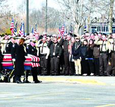 A-casket along saluting officers