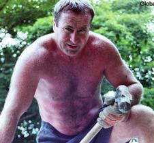 shirtless man roofing house