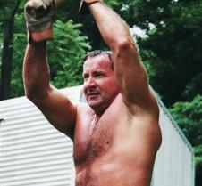 sweaty man swinging sledge hammer workin